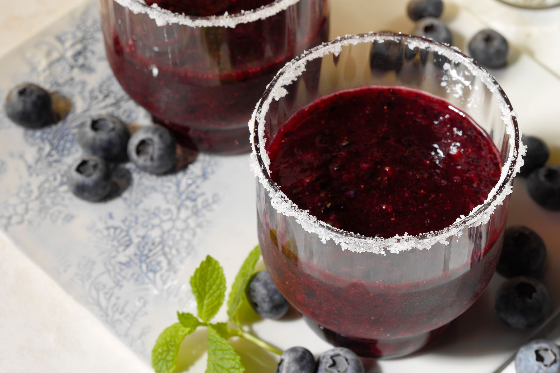Blueberry Margarita served in glasses with salt on the rim