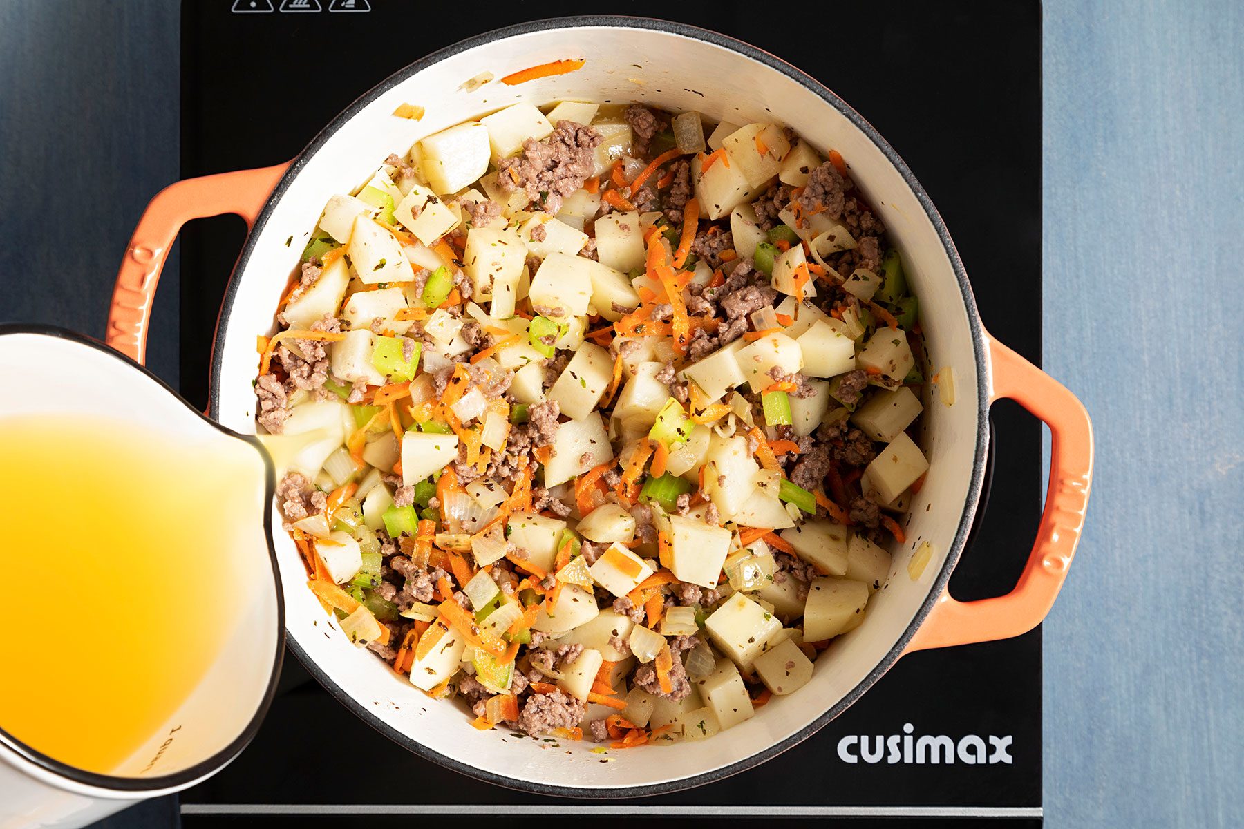 Adding Potatoes and broth into the mixture 