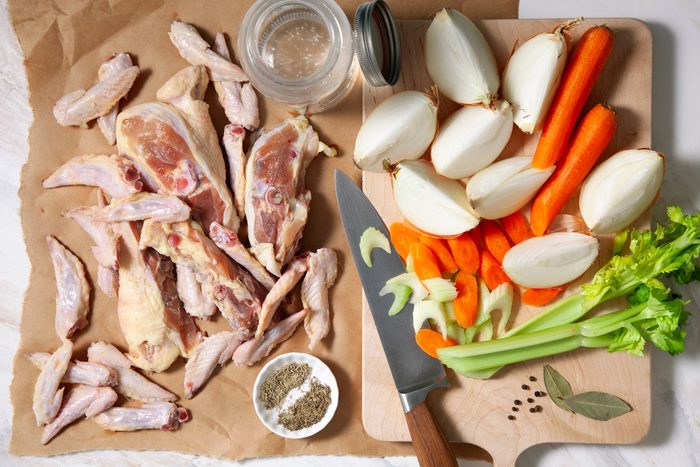 Chicken pieces with herbs and vegetables on the table