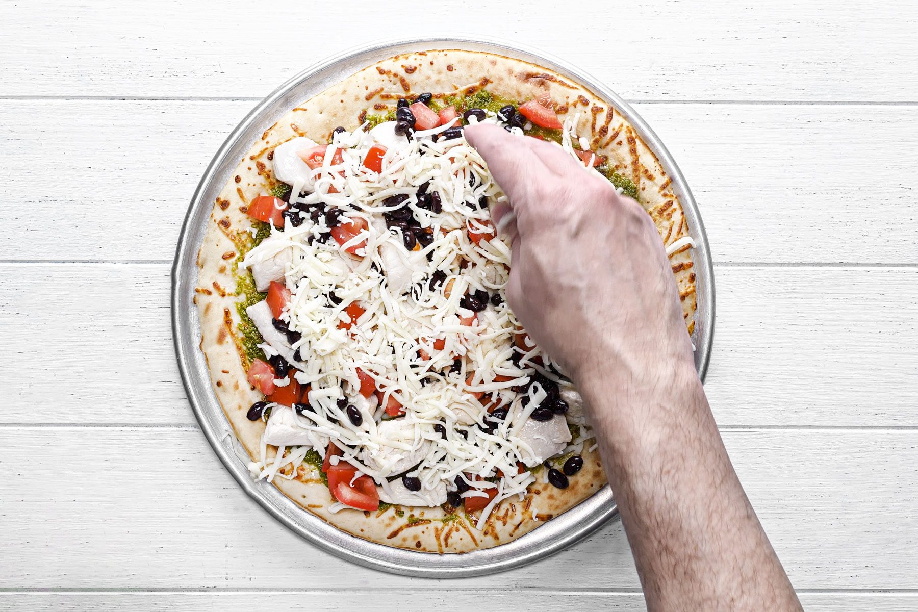 Tomato cheese and beans spread on the top of pizza crust