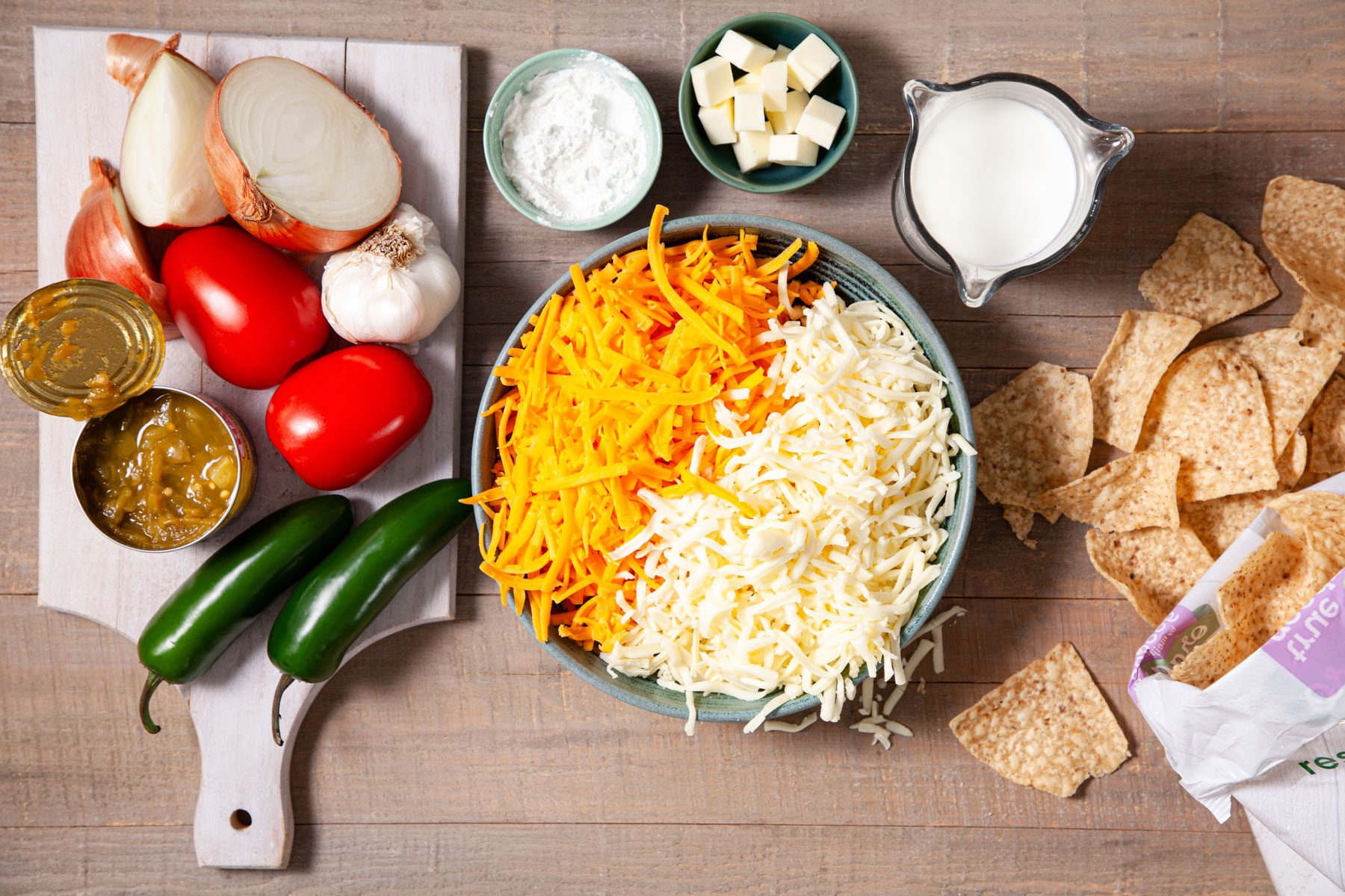 Green chilli, onion and other ingredients on a wooden table to prepare Chili Con Queso 