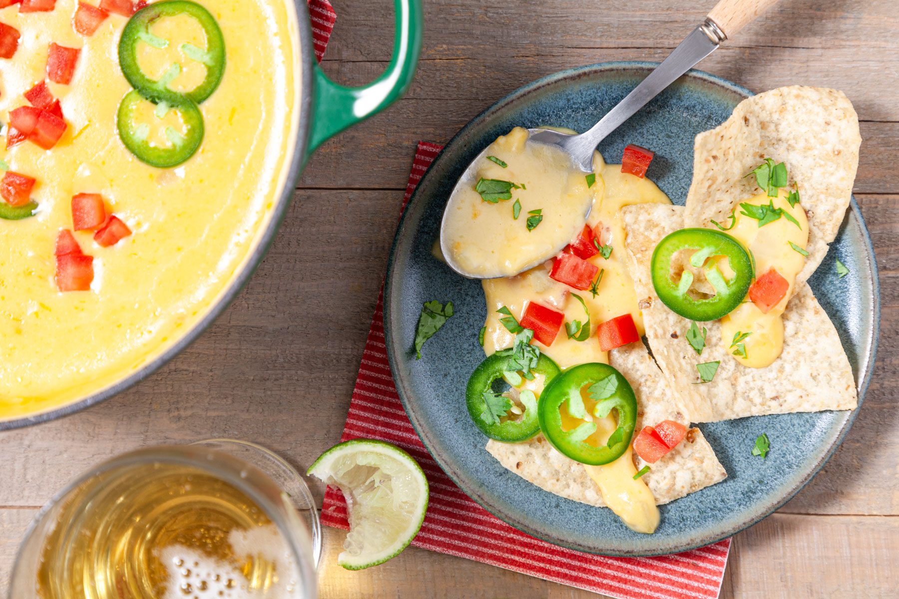 Chili Con Queso served with chips in a plate with a drink 