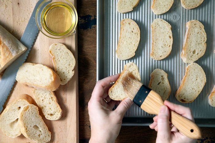Applying the oil on baguette slices with a brush