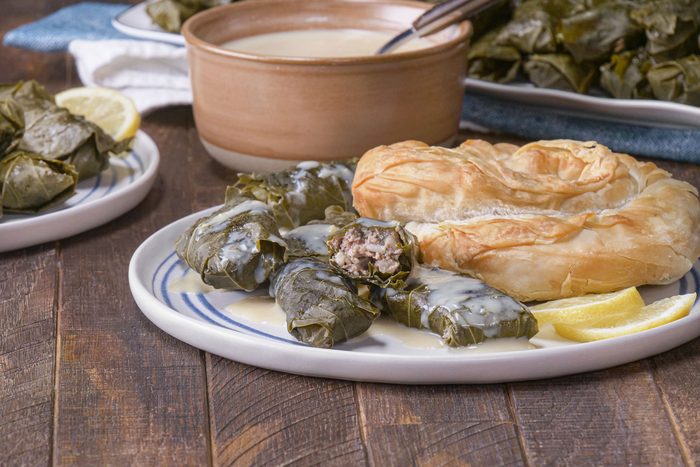 Dolmades With Avgolemono Sauce in a plate served with lemon and bread