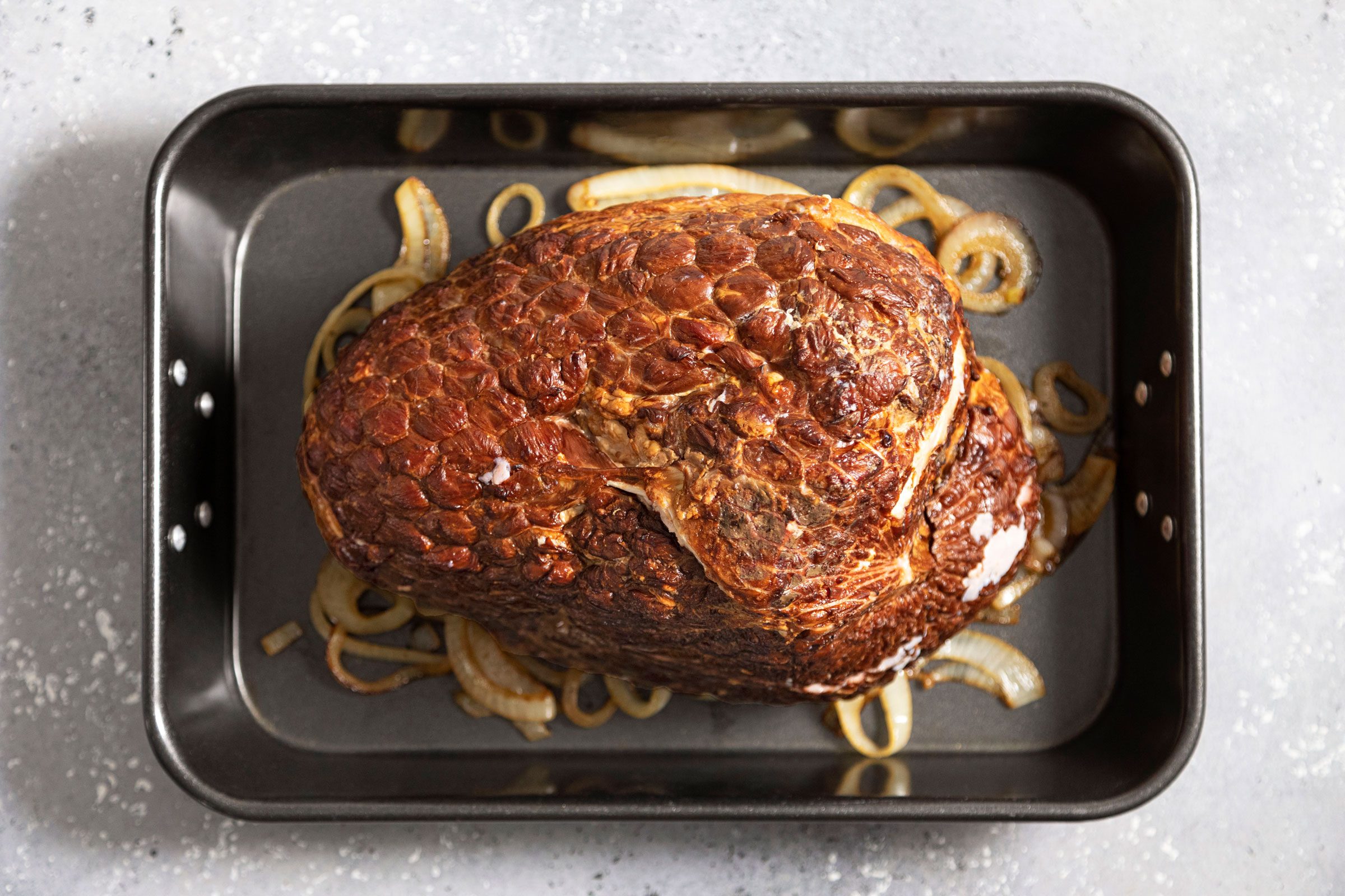 ham on top of onions in a baking pan