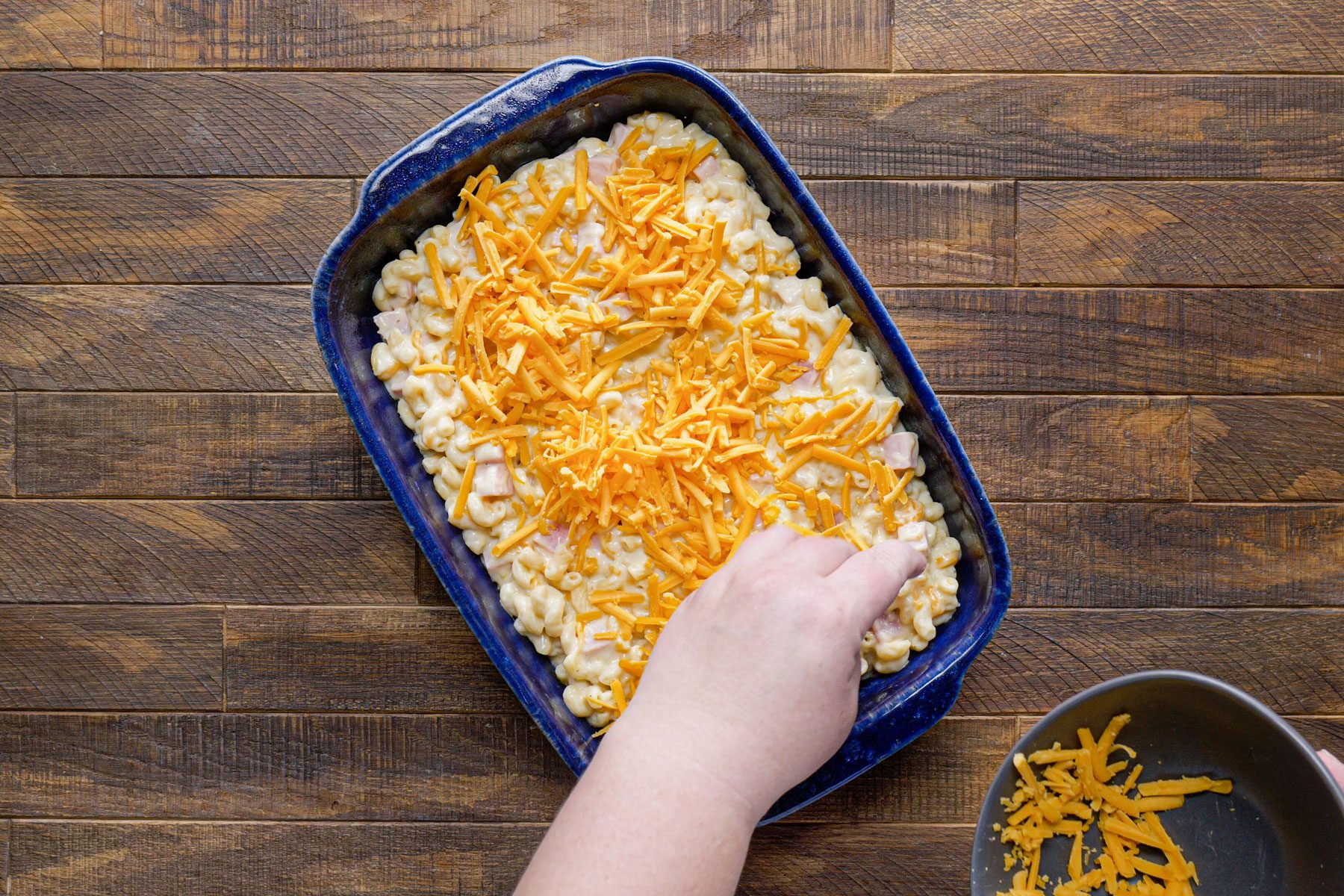 Sprinkling pasta with the cheddar cheese