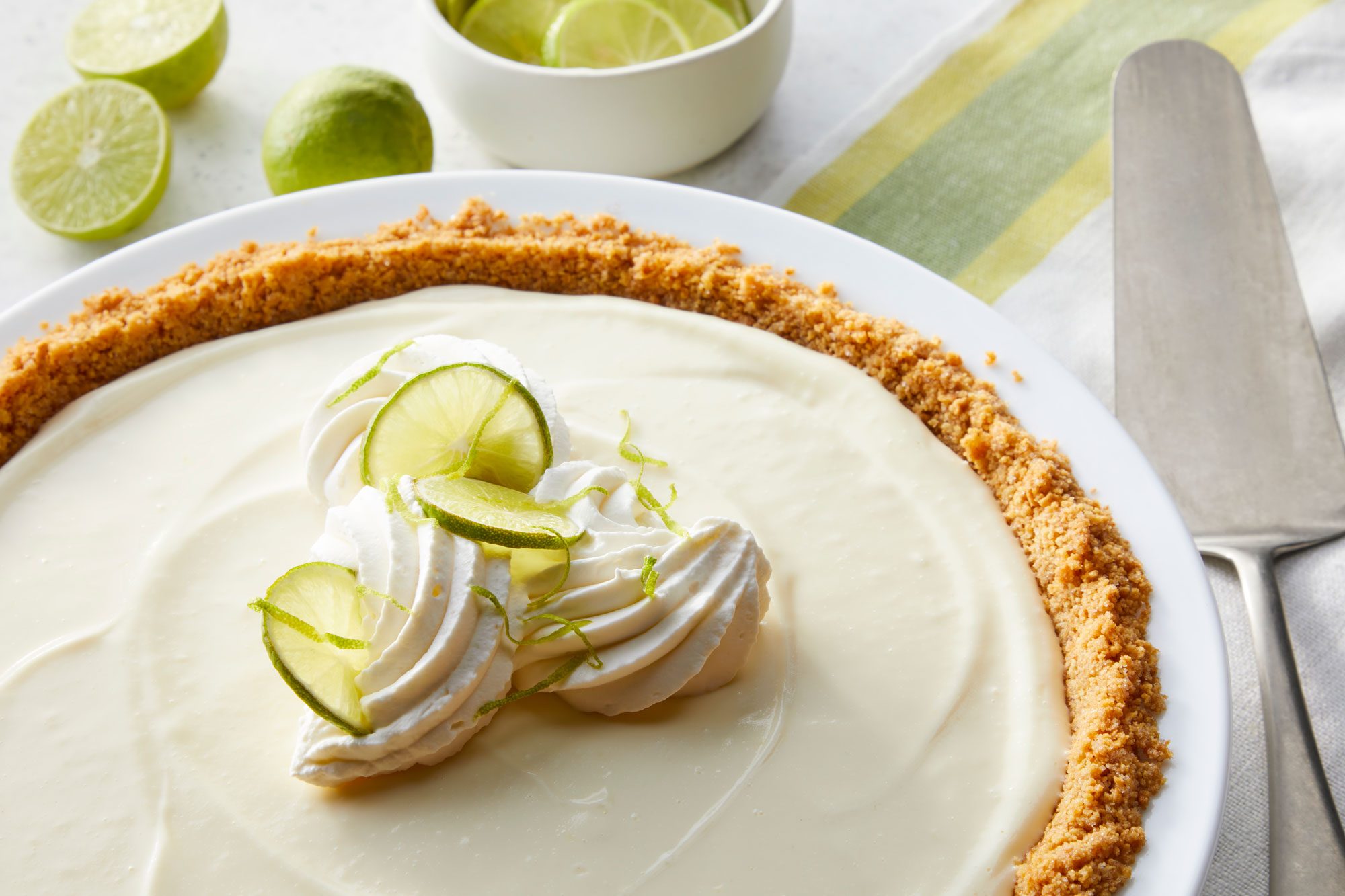 No Bake Key Lime Pie on a pie plate with some sliced lemons