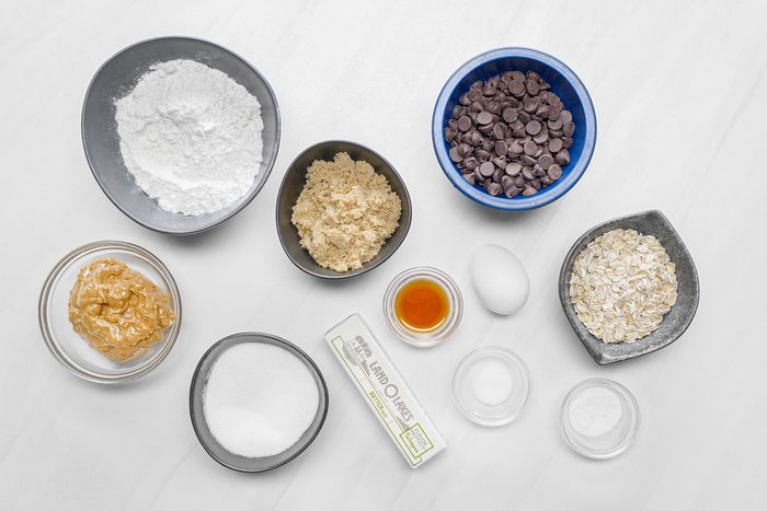 Ingredients for Peanut Butter Chocolate Chip Cookies on white surface