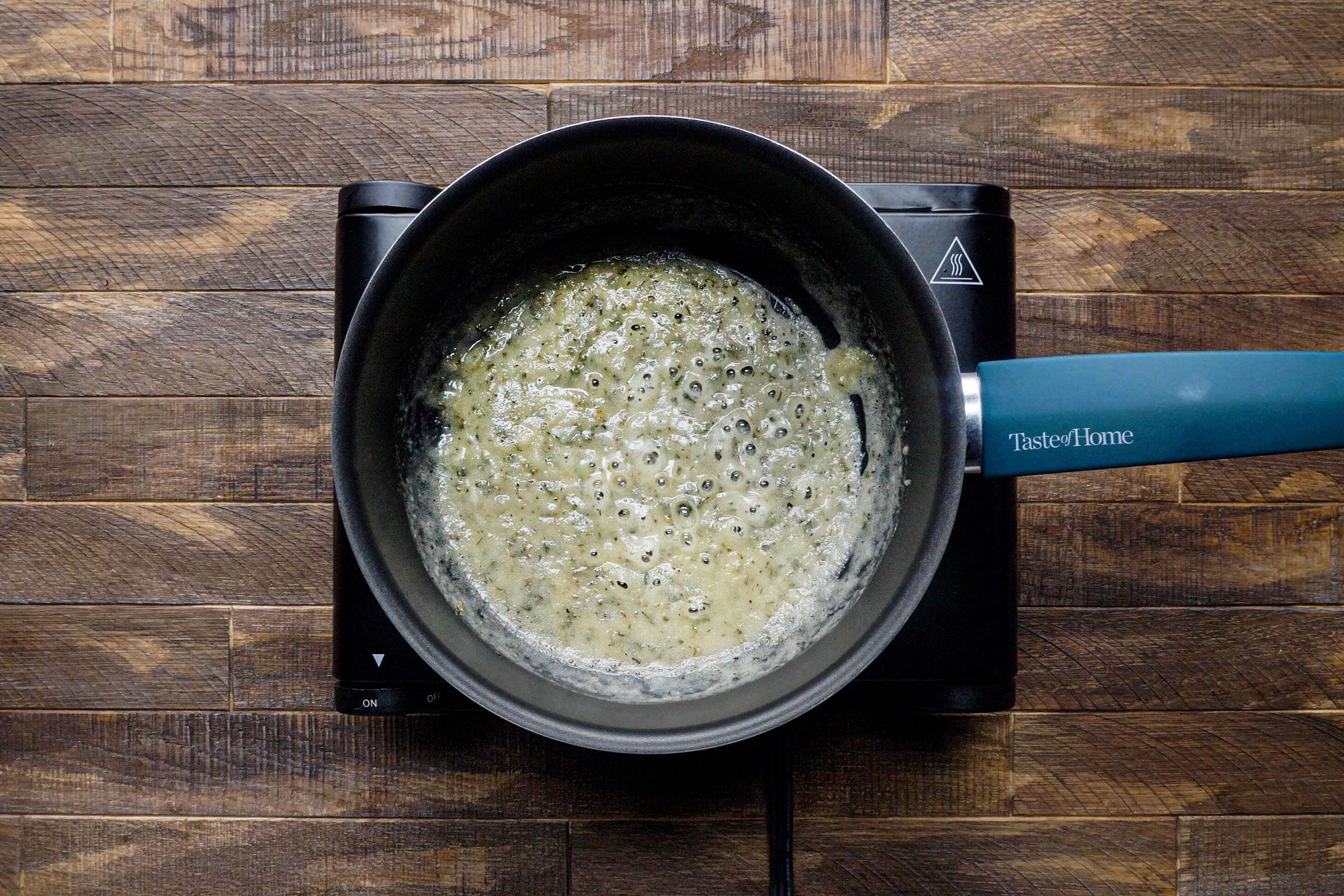 Melting Butter in a Saucepan on a gas stove on a Wooden Surface