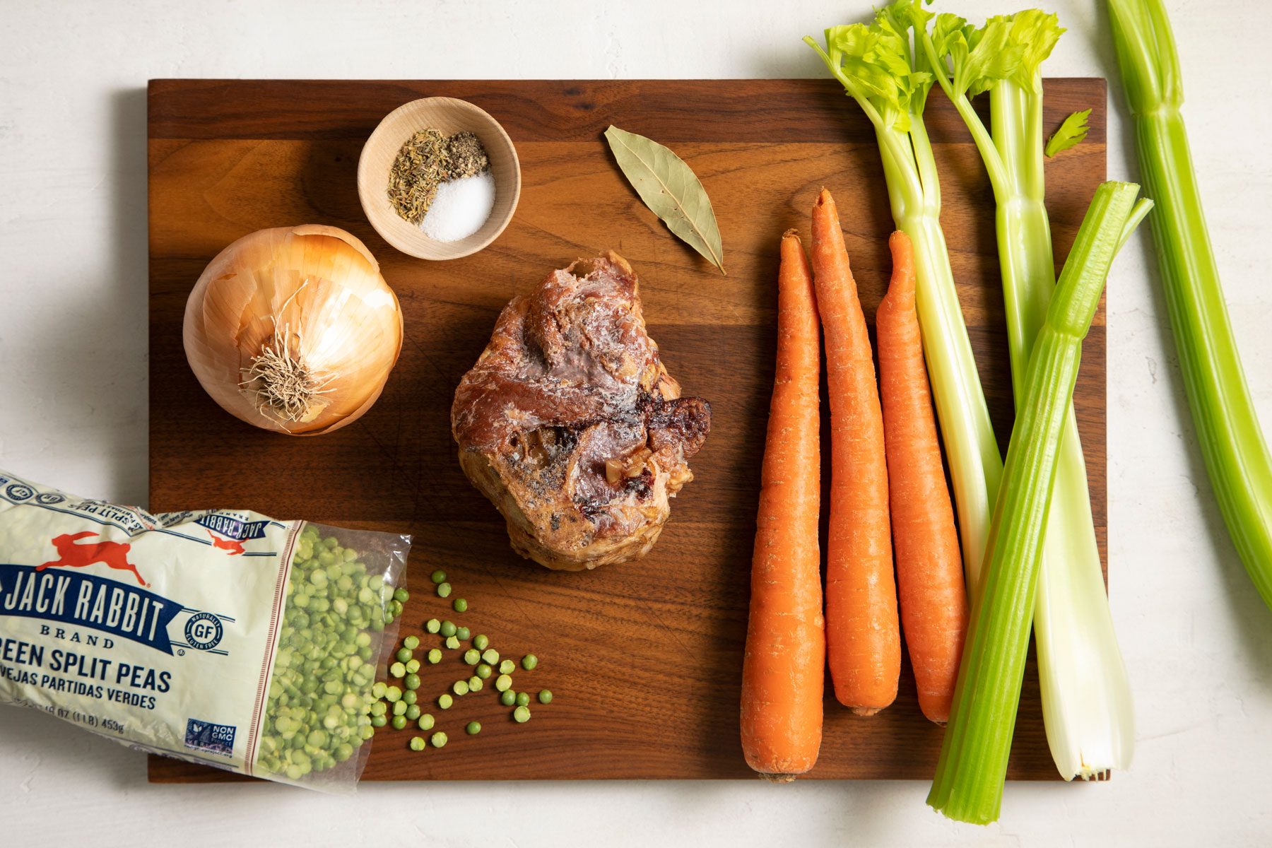 Ham bone and other vegetables on a wooden tray to make Split Pea Soup 