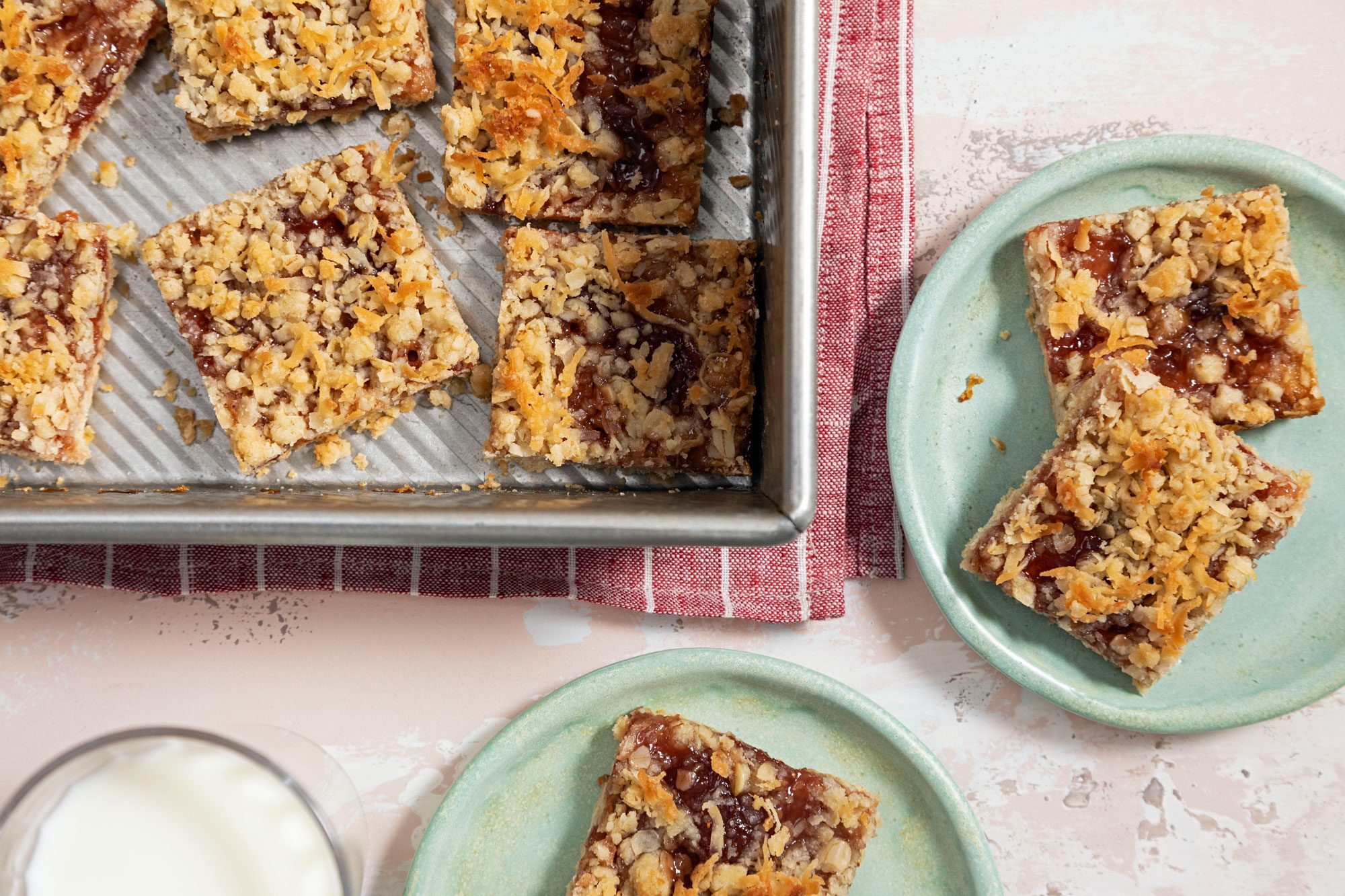 Strawberry Oatmeal Bars in a Deep Baking Tray and Two Strawberry Oatmeal Bars Served on a Small Plate