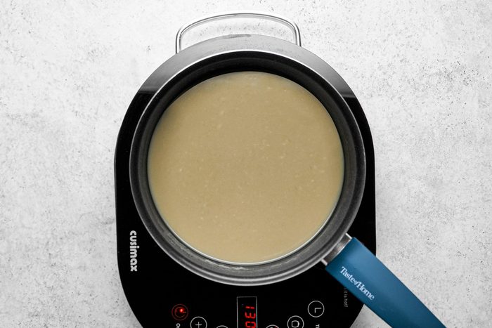 Olive color mixture sauce cooking in large skillet