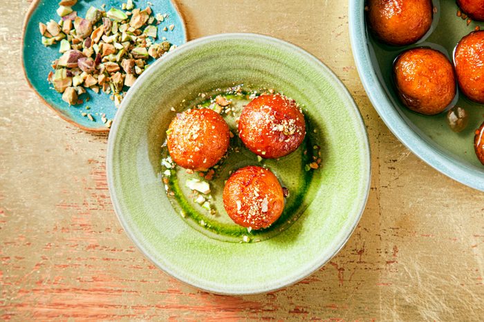 Gulab Jamun Served in a ceramic plate on wooden surface