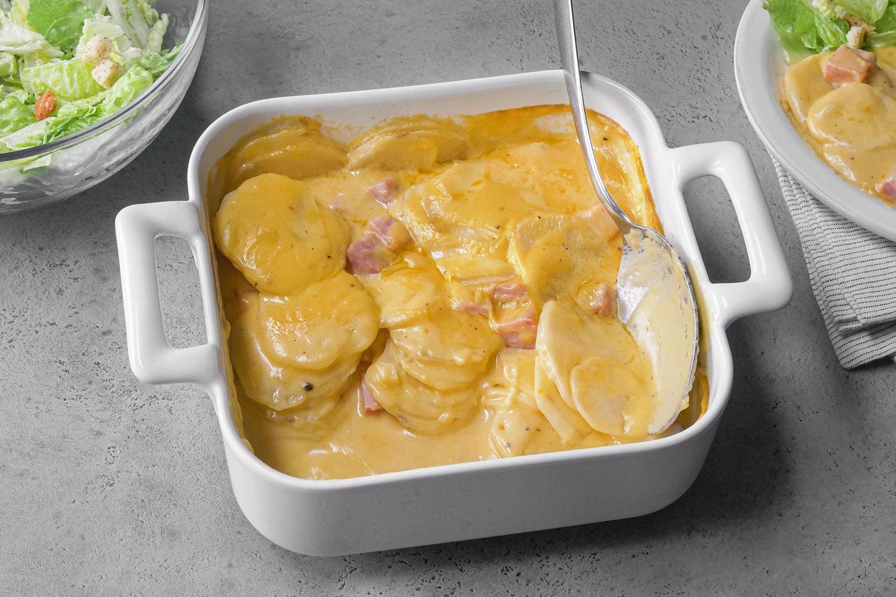 Spoon in Ham And Potatoes Au Gratin