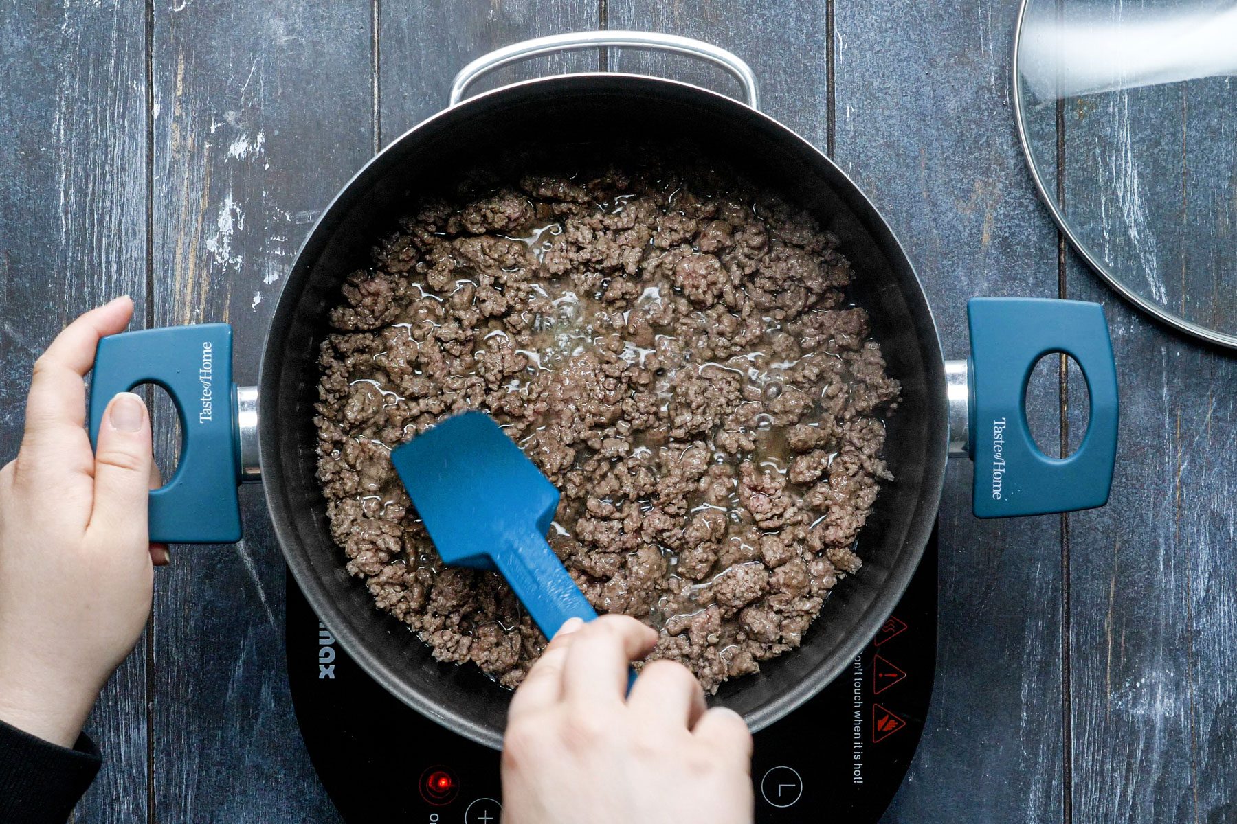 Cooking the beef in a large saucepan, stirring with a spatula