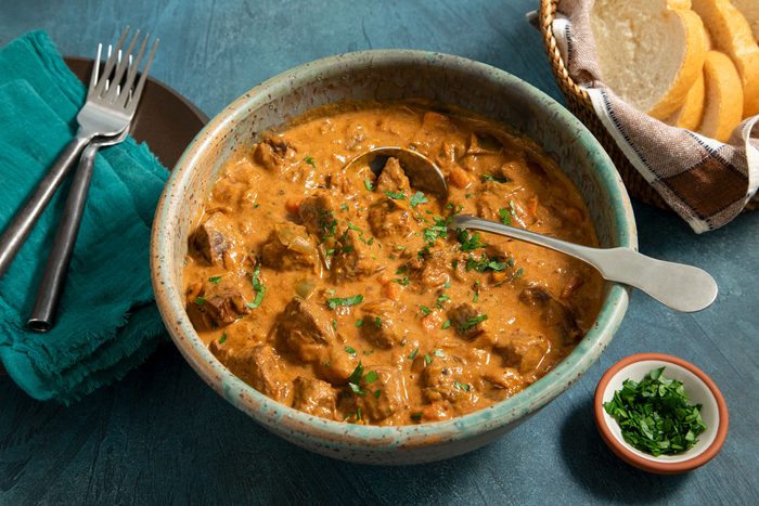 Hungarian Goulash in a large bowl served with bread and fork placed on side