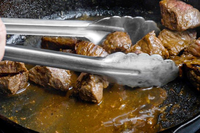 Cooking the meat in oil in a large skillet