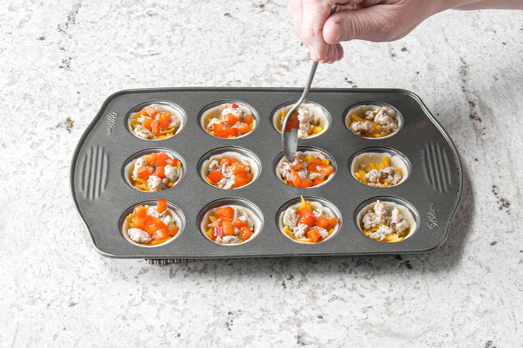 Adding toppings to dough in baking tray