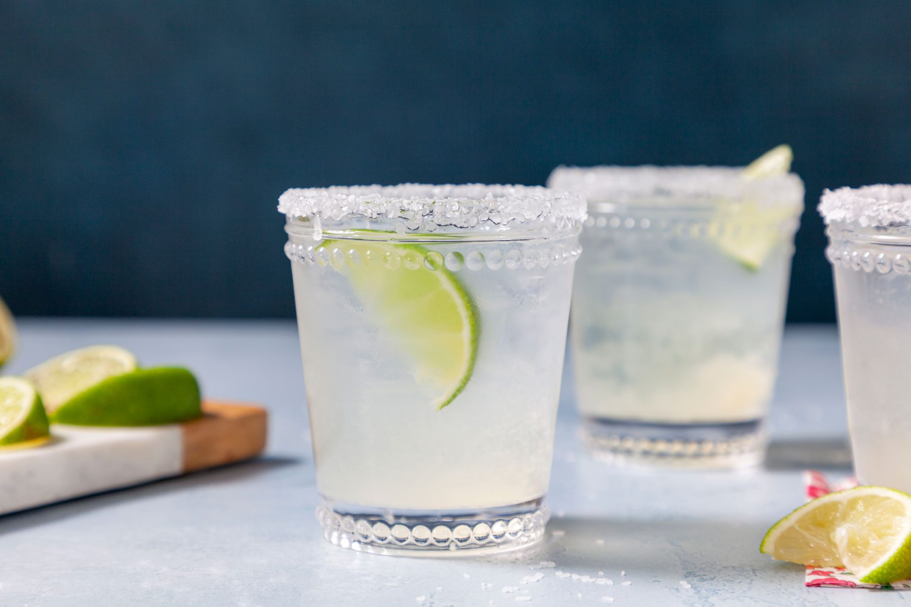 A slice of lemon inside Pitcher Margaritas served in a glass