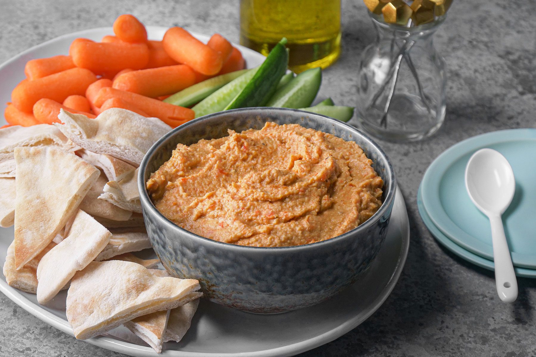 Humus served with pita bread, carrots, cucumbers and crackers