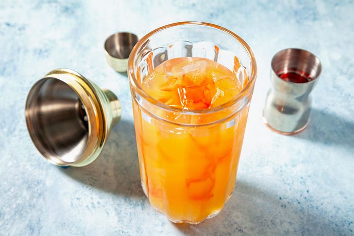 high angle shot of sweet rum punch in a shaker with ice