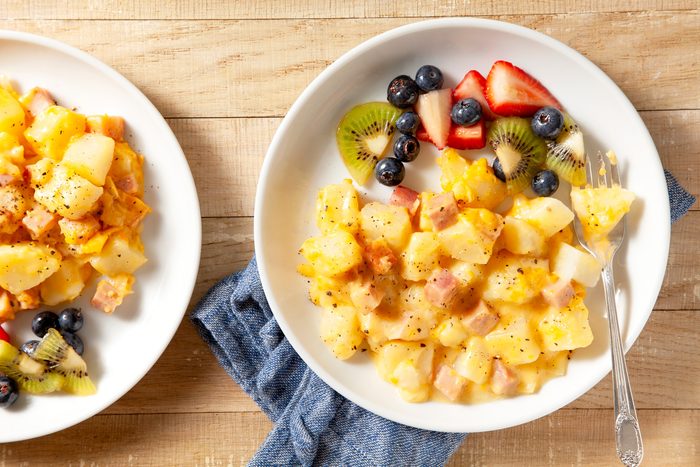 overhead shot of cooked ham and potatoes served with fruits