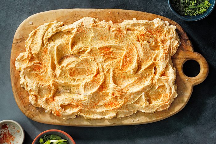 A wooden platter with Herbed Butter on it
