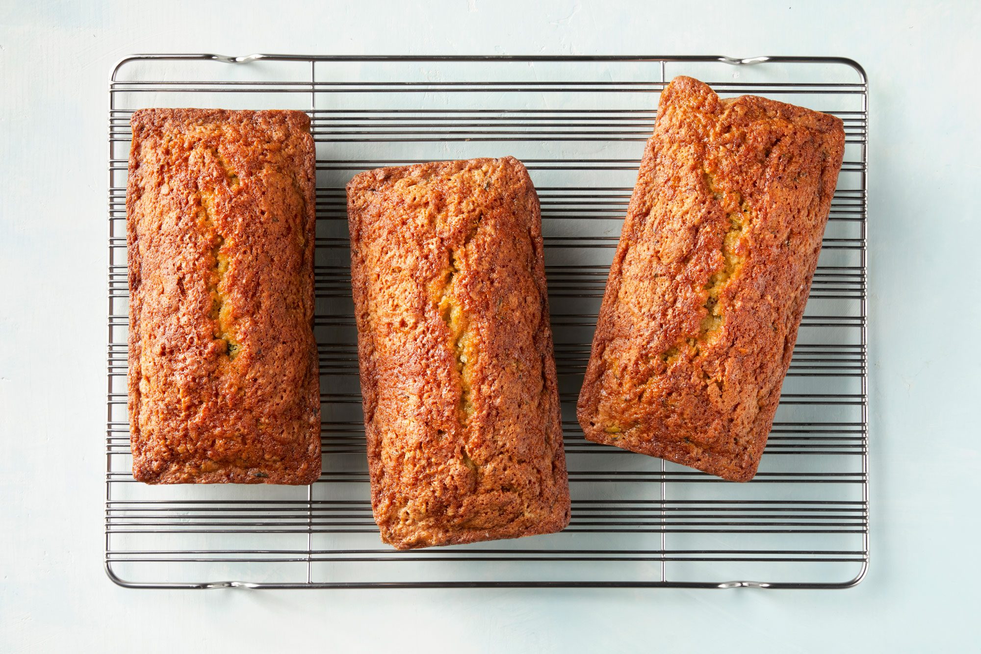 overhead shot of pina colada zucchini bread loaf on a wired rack