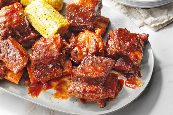 A plate of pressure cooker barbecued beef ribs served with corn on the cob