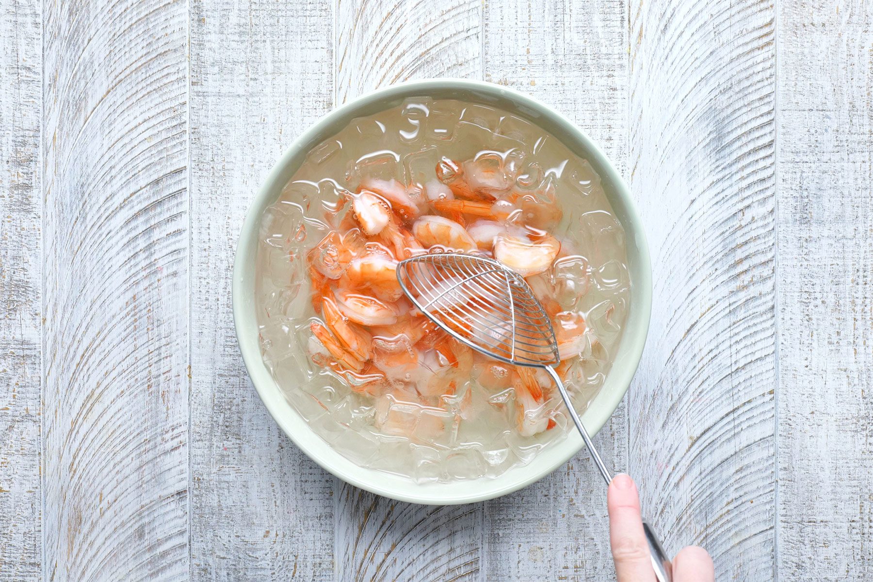 overhead shot of shrimps in a bowl of ice water