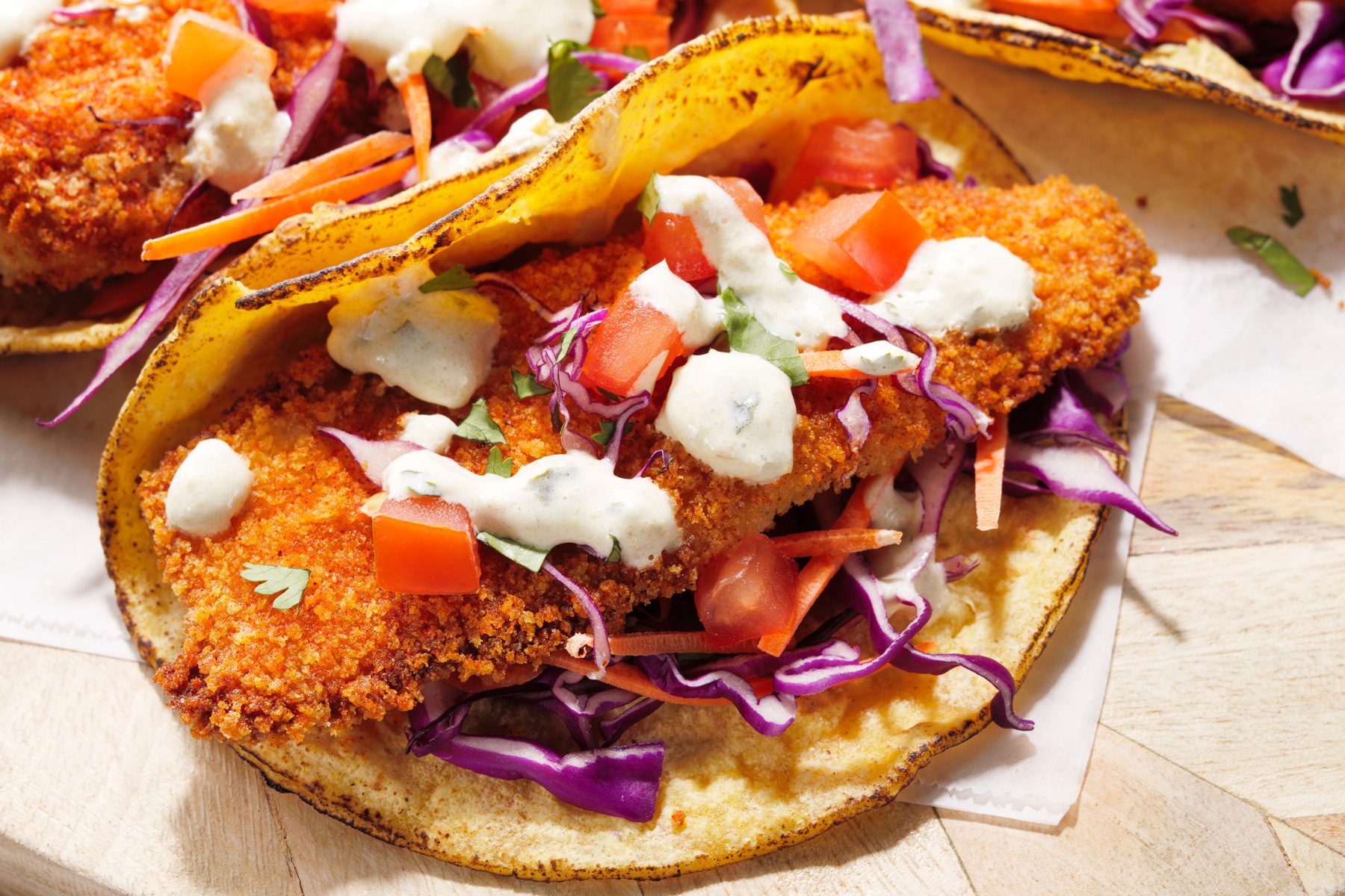 Air-fryer fish topped with tomatoes, shredded cabbage, and carrots