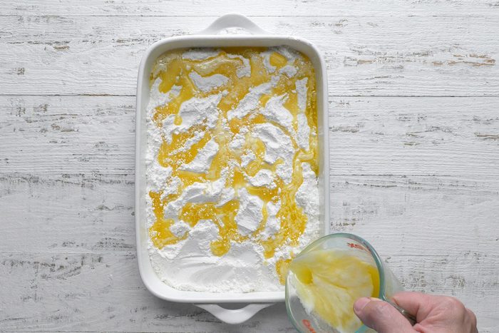 overhead shot of butter poured over cake mix in a baking dish