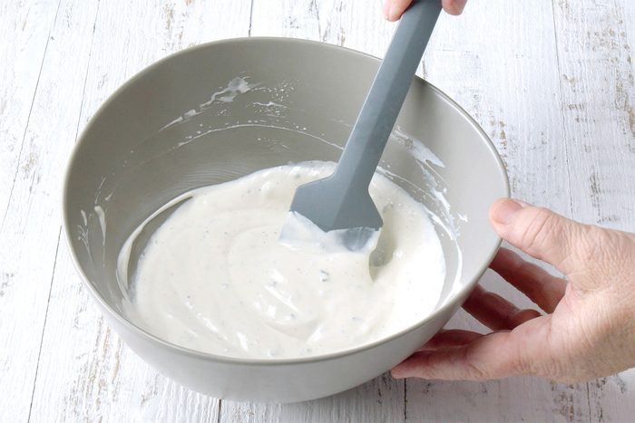 wide shot of stiring blue cheese in a bowl