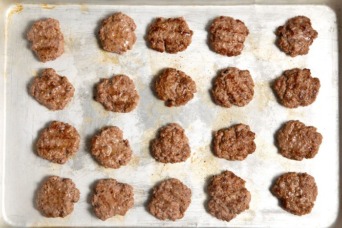 overhead shot; grilled burger patties placed on a frying dish;