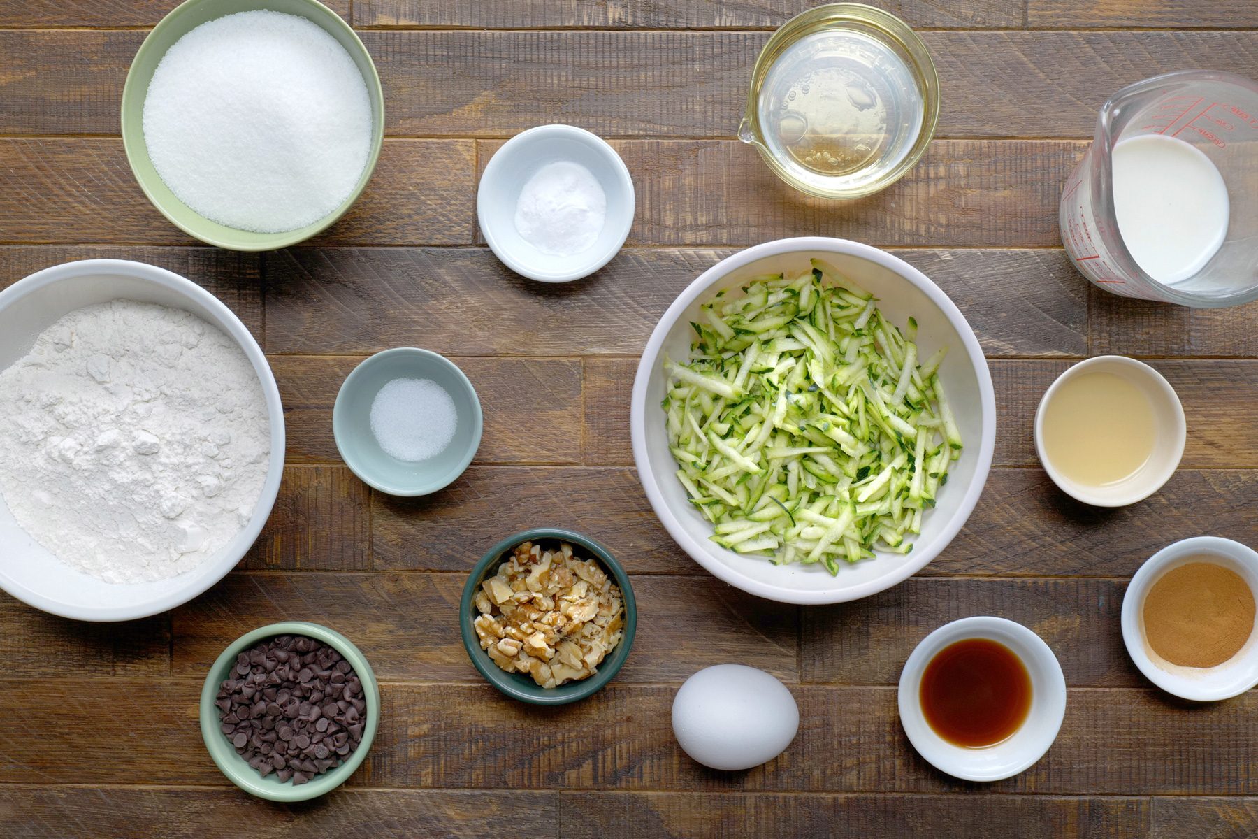 Ingredients for Chocolate Chip Zucchini Muffins on a wooden table