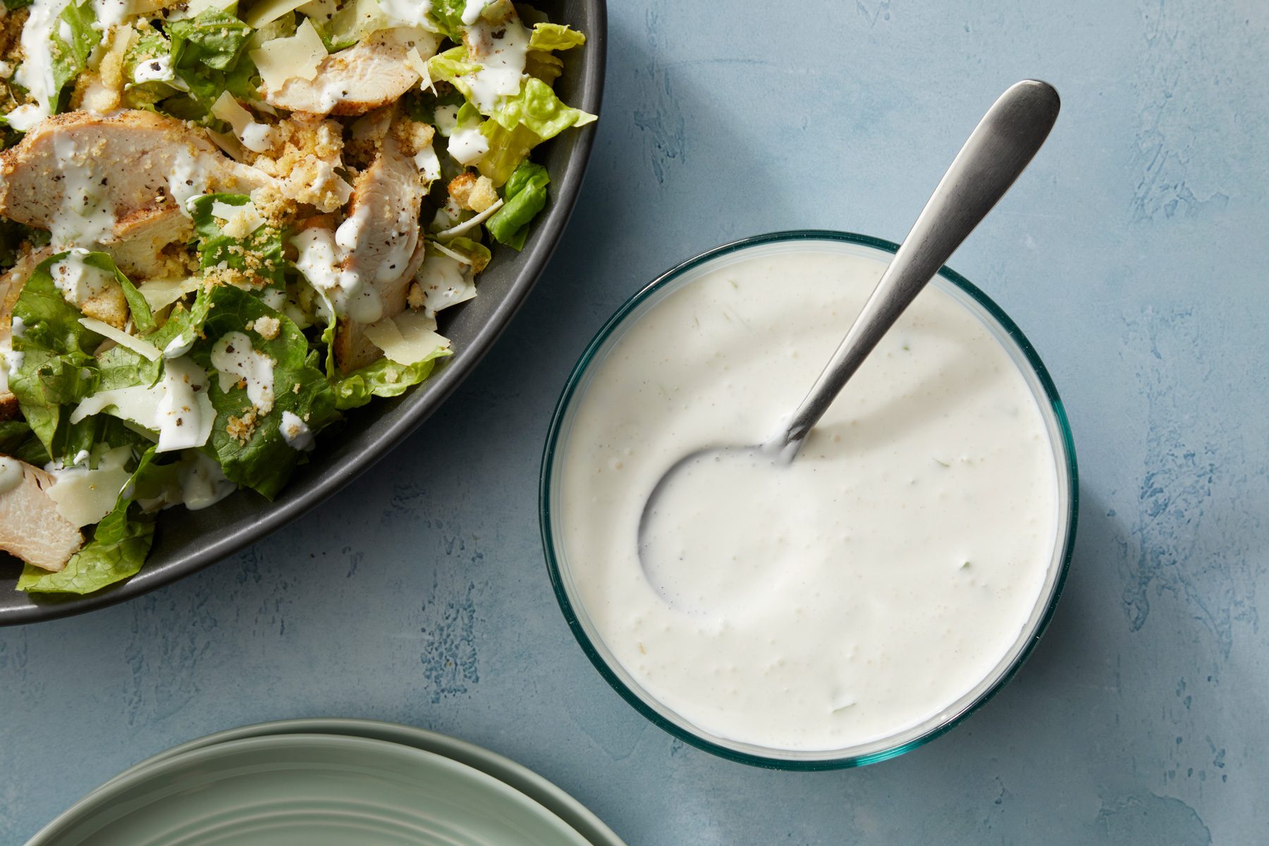 A bowl of Creamy Garlic Salad Dressing on a table.
