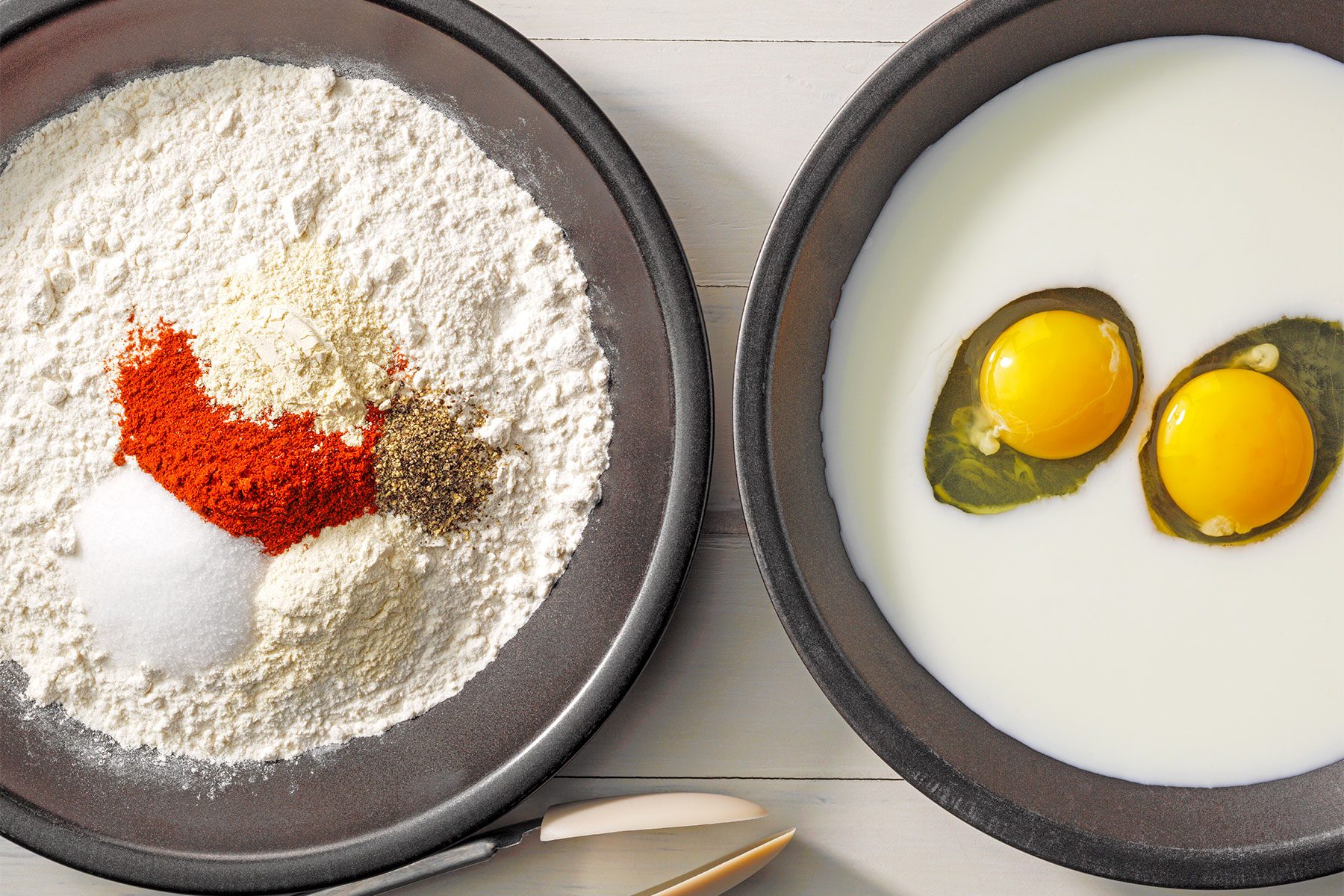 Top view shot of a shallow bowl; combined the first 6 ingredients; in another shallow bowl; whisk eggs and milk; tongs; wooden background;