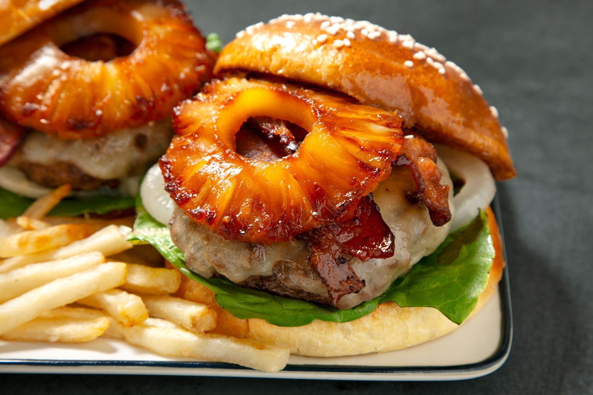 close shot; horizontal shot; Hawaiian Burgers served with fries in a plate;