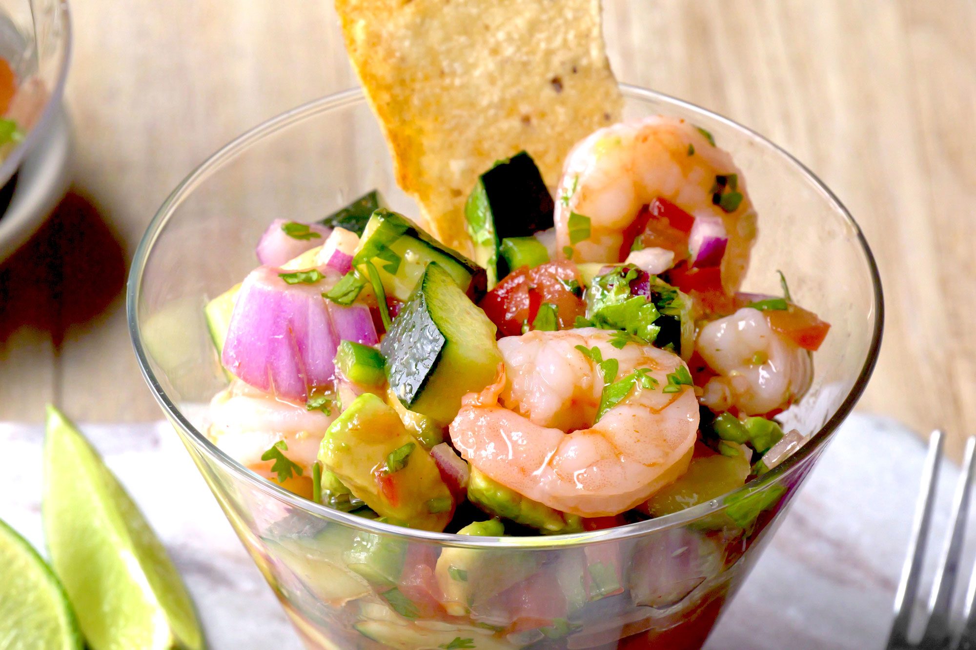 Appetizing Easy Mexican Shrimp Cocktail in glass with chips and lime wedge