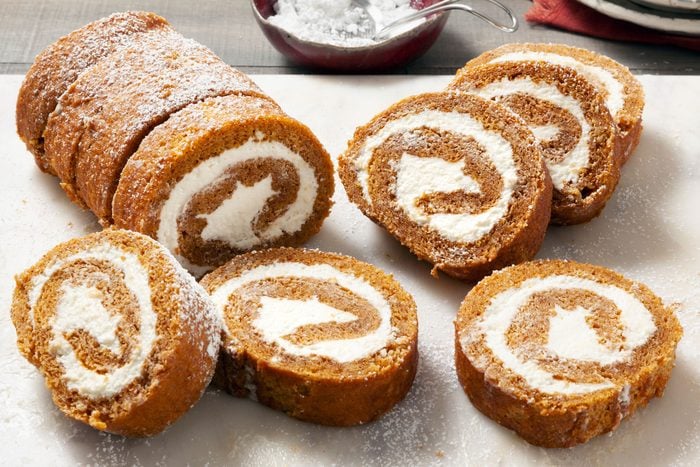 3/4 angle shot of Pumpkin Rolls; marble background; knife;