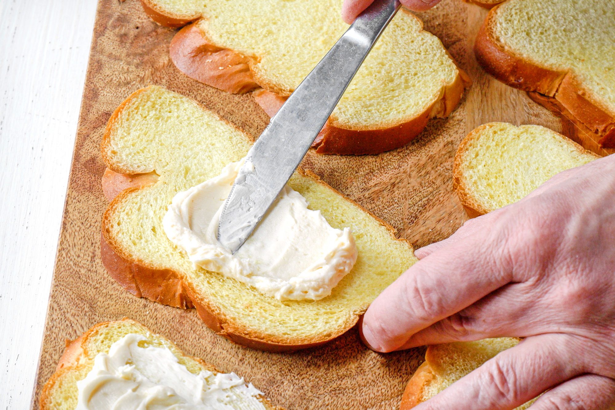 wide shot of cheese cream mixture spreaded over bread slices