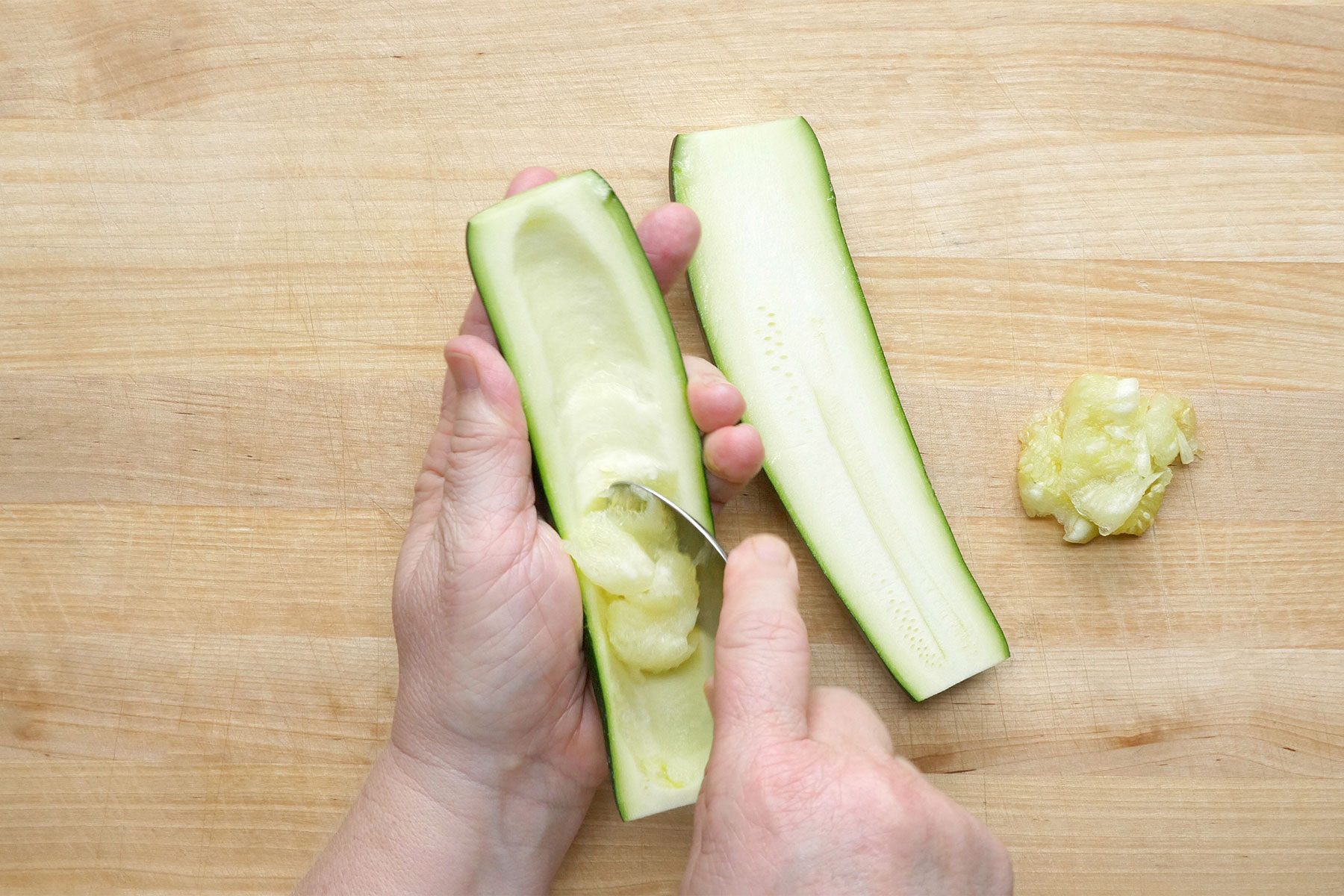 Overhead shot of scoop out pulp of zucchini; wooden background;