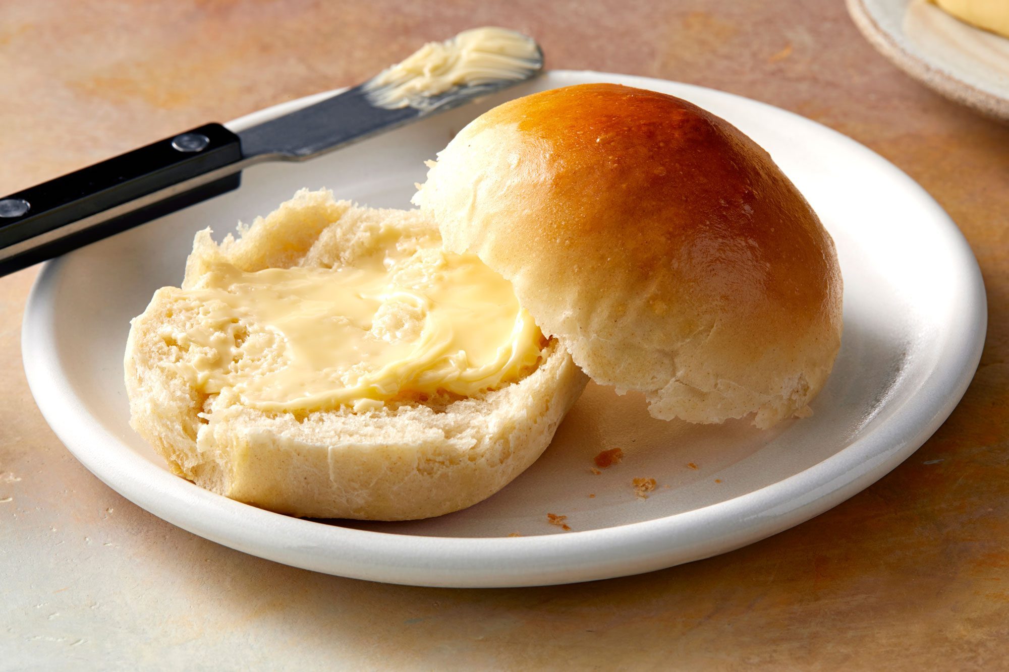 Best Dinner Roll with butter served in a white plate