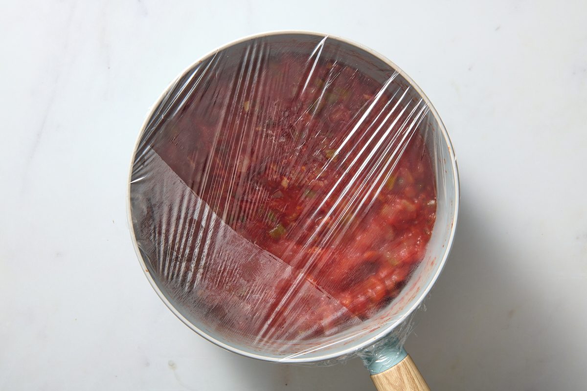 Covering the salsa with film ready for chilling