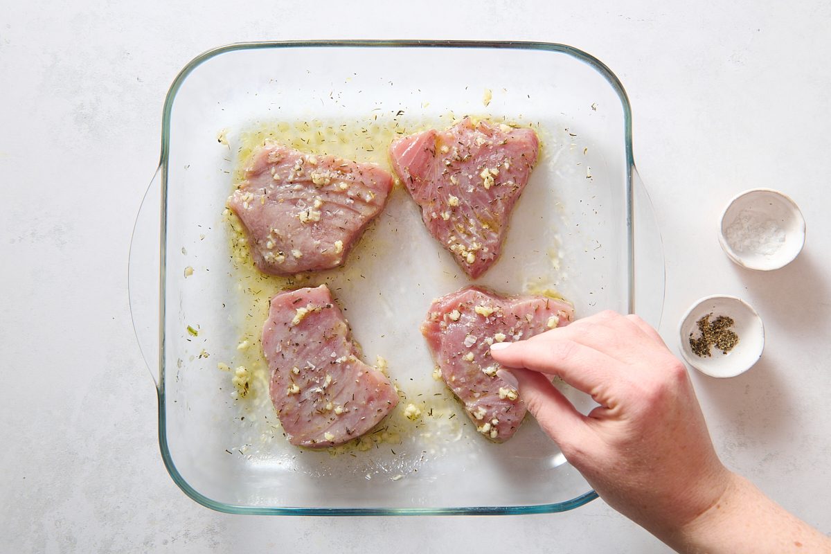 Sprinkling salt and pepper on the steaks