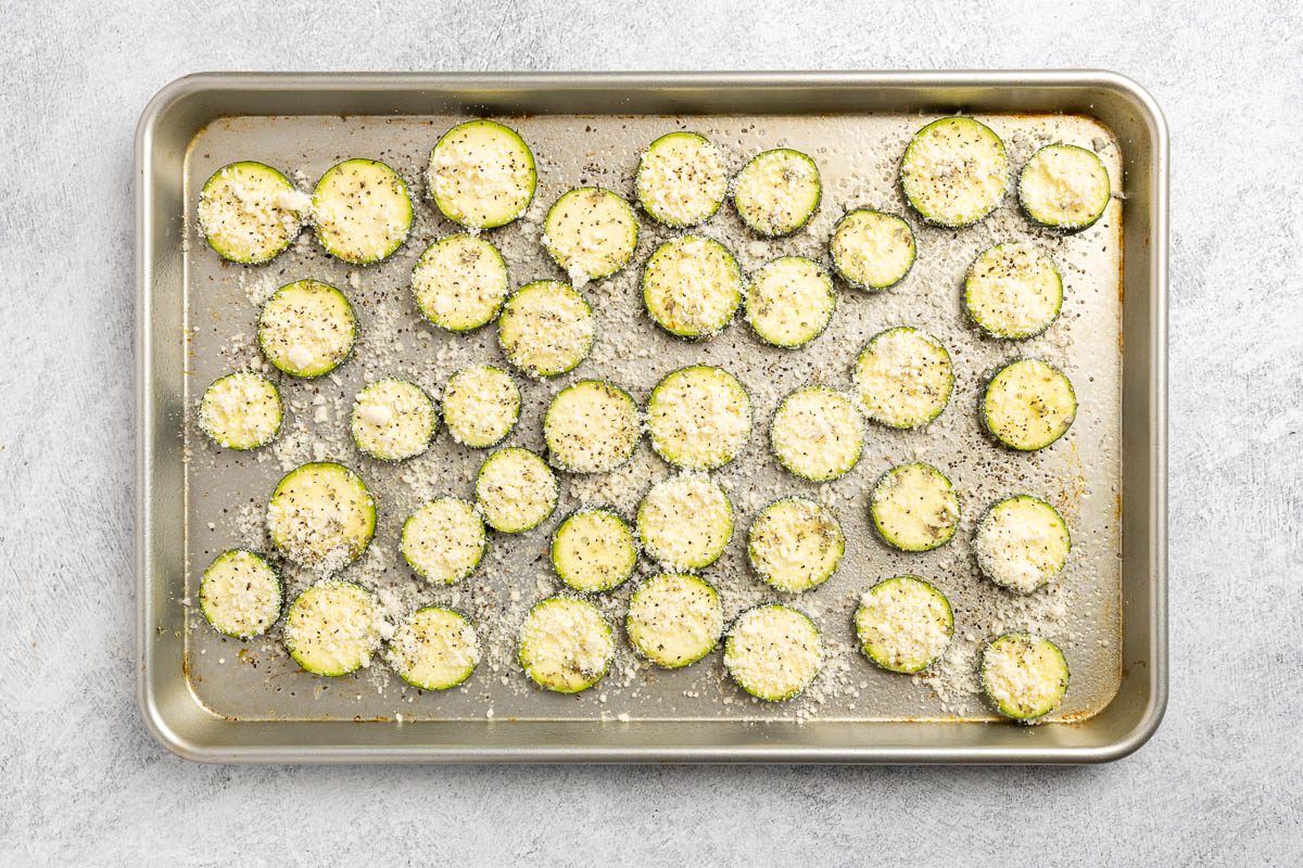 Taste of Home roasted zucchini recipe photo of raw zucchini placed on a sheet pan and seasoned.