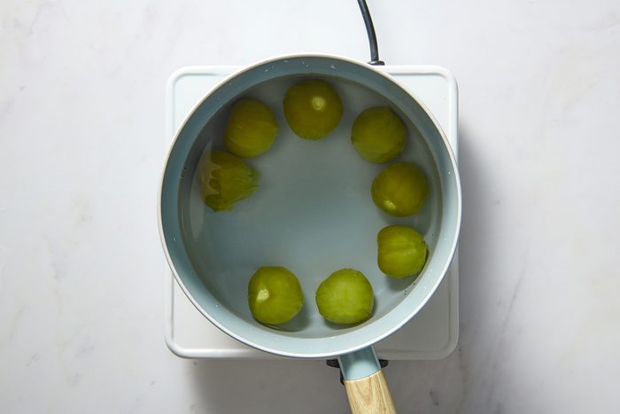 Tomatillos being cooked in a pan