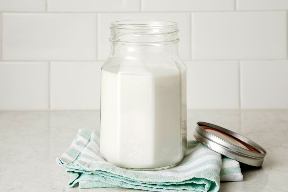 Coconut milk in a glass on a kitchen counter