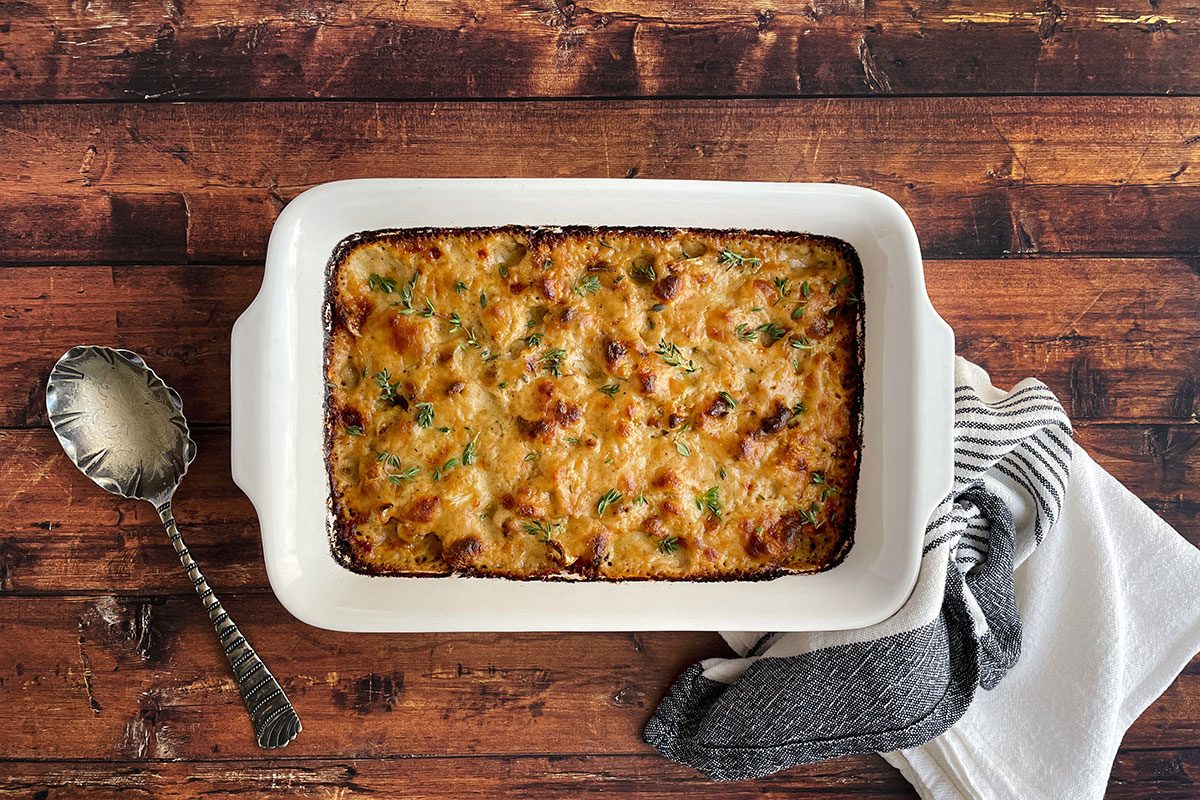 Overhead shot of Taste of Home's Cauliflower Gratin in a baking dish on a dark wood background