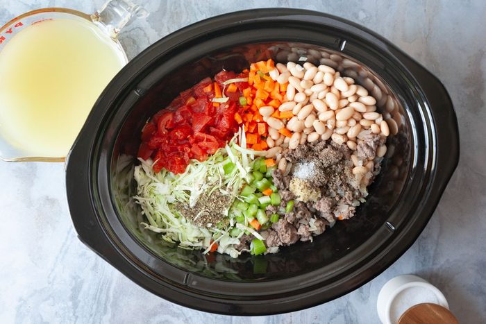 Step 2 of Taste of Home Crockpot Pasta Fagioli is adding the remaining ingredients into a slow cooker